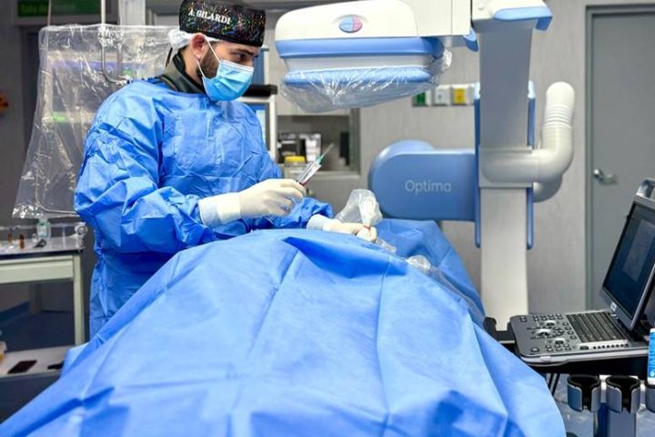 Equipo médico durante un procedimiento de cirugía vascular mínimamente invasiva.