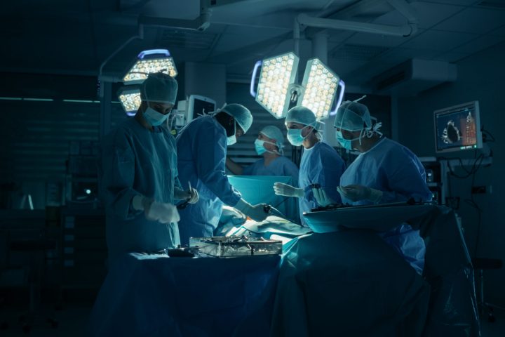 Surgeons and Assistants Maintain Steady Hands and Clear Communication as They Continue the Delicate Work of the Ongoing Surgery. Specialists Staying Calm, Monitoring Vital Readouts On the Screens
